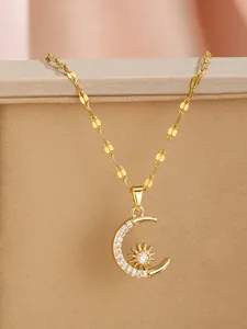 Macro detail of gold star and crescent moon pendant with sparkling zircon on chic chain