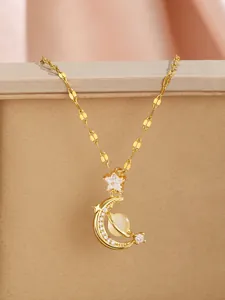Detailed close-up of gold star and moon pendant with cat eye stone on herringbone chain