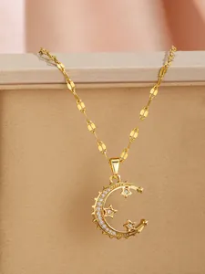 Detail of gold moon and star zircon pendant on flat link chain over a jewelry box