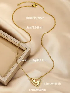 Detailed view of gold heart necklace with baby feet pendant on beige velvet fabric