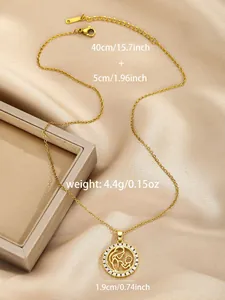 Detail of gold MAMA necklace with mother and child pendant on champagne silk fabric