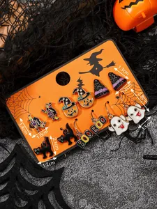 Dettaglio macro del set di orecchini di Halloween con strega, fantasma e zucca su carta