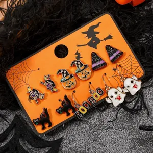 Set di orecchini di Halloween con zucche, fantasmi e gatti neri su carta arancione