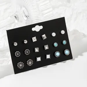 Detailansicht eines 9-Paar Ohrstecker-Sets mit Perlen und Türkis auf schwarzer Karte