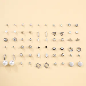 Set van minimalistische zilveren ster oorringen met parels en kristallen op beige