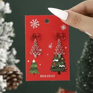 Sparkling Christmas tree stud earrings with red bow and rhinestones on holiday card