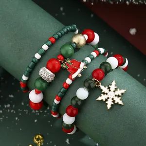 Set of four Christmas beaded bracelets featuring festive red green white beads and snowflake charm