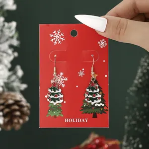 Festive Christmas tree dangle earrings with enamel finish on holiday card display