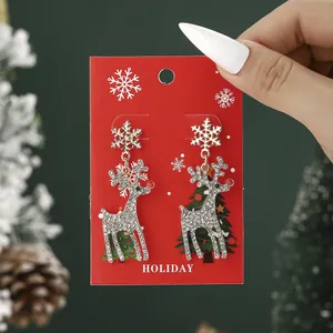 Christmas reindeer and snowflake stud earrings set with rhinestones on holiday card