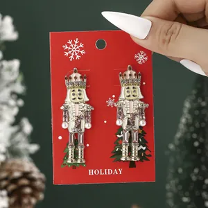 Nutcracker rhinestone earrings with pearls on red holiday card against Christmas pine needles