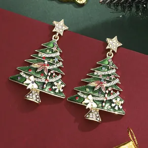 Pendientes de árbol de Navidad con cristales de colores y lazo blanco en fondo rojo
