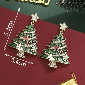 Pendientes de árbol de Navidad con esmalte verde y strass sobre fondo granate