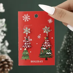 Golden snowflake and red Christmas tree earrings with pearls on festive holiday card