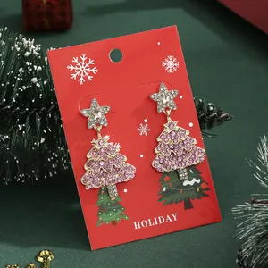 Kerst ster oorbellen met roze stras kerstboom hanger op een feestelijke kaart