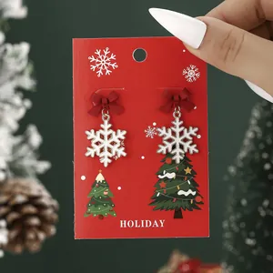 Christmas snowflake earrings with red ribbon bows on a festive holiday card