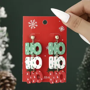 Three-layer acrylic HO HO HO Christmas tree earrings with festive holiday packaging