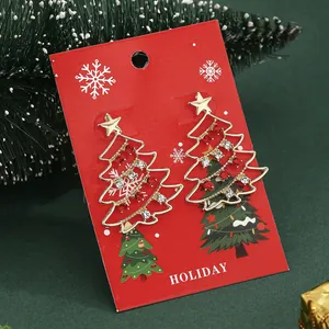 Primer plano de pendientes de árbol de Navidad con diamantes rojos y blancos en tarjeta