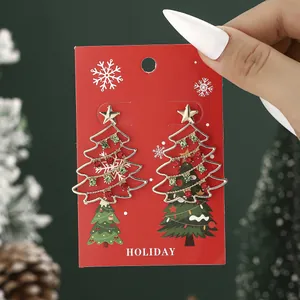 Sparkling Christmas tree earrings with red and green rhinestones on holiday card display