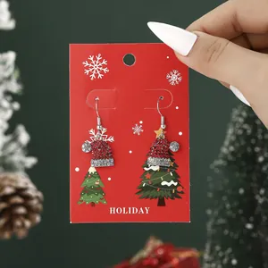 Sparkling Christmas hat earrings with red rhinestones on a festive holiday display card
