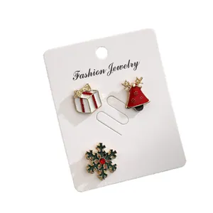 Three-piece Christmas brooch set with gift box, bell, and snowflake on display card