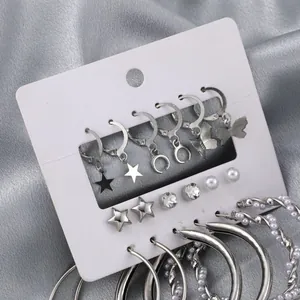 Silver earring set featuring studs with faux pearls and large hoop earrings on satin