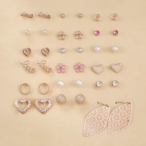 Dettaglio di un set da 15 paia di orecchini color oro rosa con perle e fiori