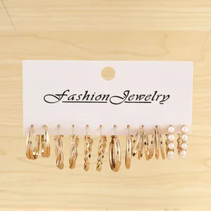 Set of six gold hoop earrings with pearl accents and minimalist textures on jewelry card