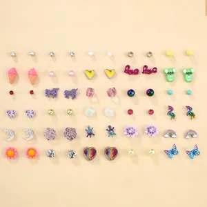 Dettaglio di un set di orecchini a perno colorati con fiori, farfalle e perle miste