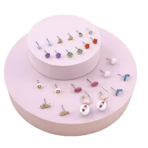 Colorful cartoon heart and mushroom earring set with gold finish on pink display