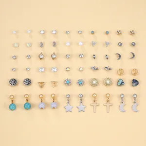 Dettaglio di un set di orecchini misti con perle, stelle e chiodini geometrici dorati