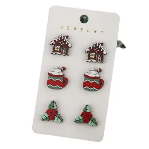 Christmas stud earring set featuring gingerbread house and cocoa designs on a card