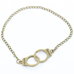 Vintage bronze handcuff necklace with Freedom engraving on minimalist white background