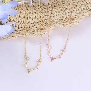 Minimalist gold and rose gold reindeer antler necklaces on a rustic background
