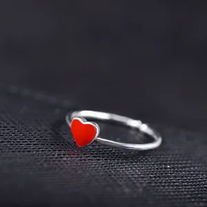 Fashionable adjustable silver open ring featuring a vibrant red heart-shaped charm