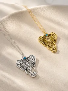 Detail of vintage elephant pendant with hollow texture and turquoise inlay accents
