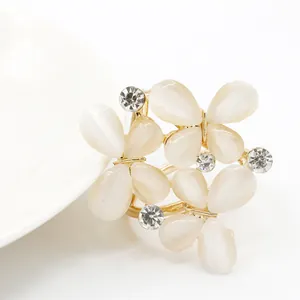 Detailed macro view of a floral silk scarf buckle with opal petals and rhinestones