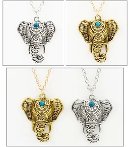 Detailed view of bohemian hollow elephant pendant with turquoise stone in gold and silver