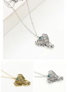 Detail of bohemian elephant head pendant with blue bead in gold and silver finish