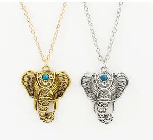 Close-up of vintage elephant pendants in gold and silver with turquoise stone details
