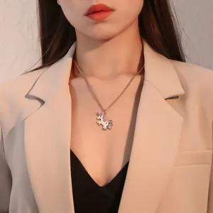 Detailopname van een kleurrijke eenhoorn hanger ketting gedragen door een model goud
