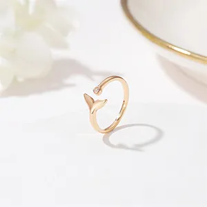 Macro shot of the mermaid tail design and tiny zircon on a gold adjustable ring