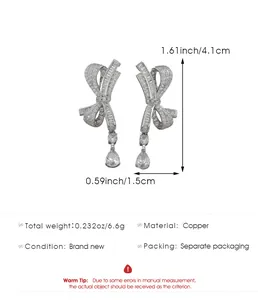 Close-up of silver-tone bow earrings with sparkling cubic zirconia and pear drop detail