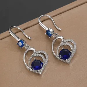 Detail view of heart-shaped earrings with blue crystals and pavé rhinestones