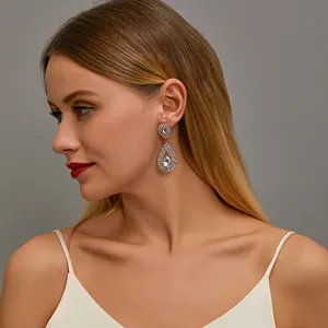 Elegant gold drop earrings with zircon crystals shown on a model against a neutral background