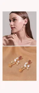 Close-up of elegant rose flower drop earrings with white pearls on golden silk background