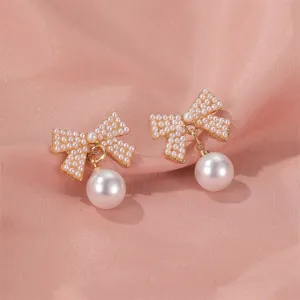 Elegant long crystal and pearl bow earrings featuring gold-plated fringe and tassels