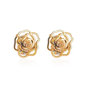 Elegant gold hollow rose stud earrings with sparkling crystal center on white background