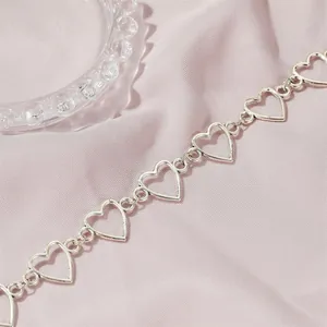Minimalistische silberne Herzgliederkette präsentiert auf elegantem rosa Seidenstoff
