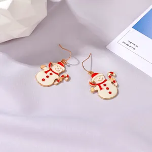 Dettaglio degli orecchini a pupazzo di neve con sciarpe rosse e bastoncini di zucchero