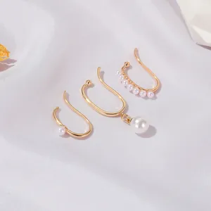Three-piece gold pearl ear cuff set featuring single and hanging pearls on white silk